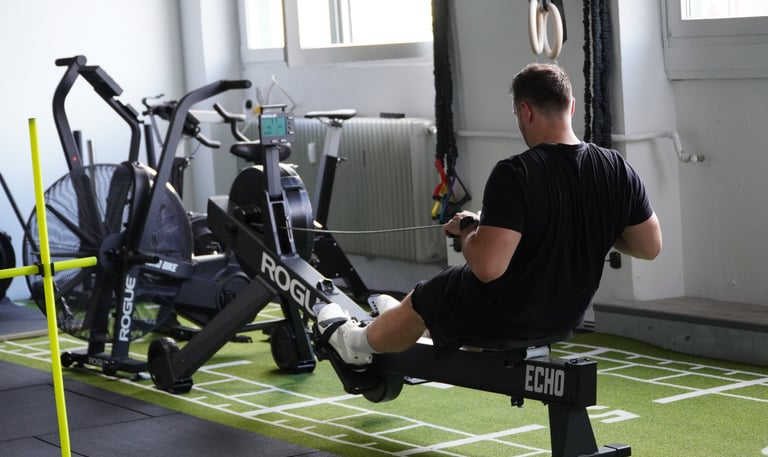 Mann sitzt auf Rudergerät im Gym