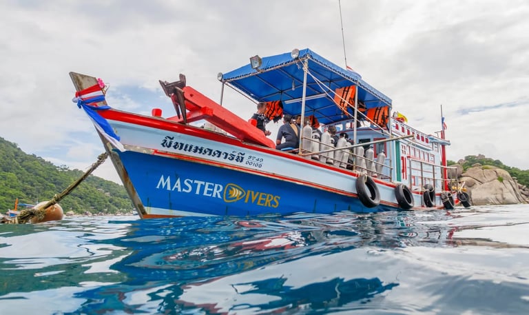 A Master Divers scuba diving boat anchored in the tropical blue waters of Koh Tao, Thailand.