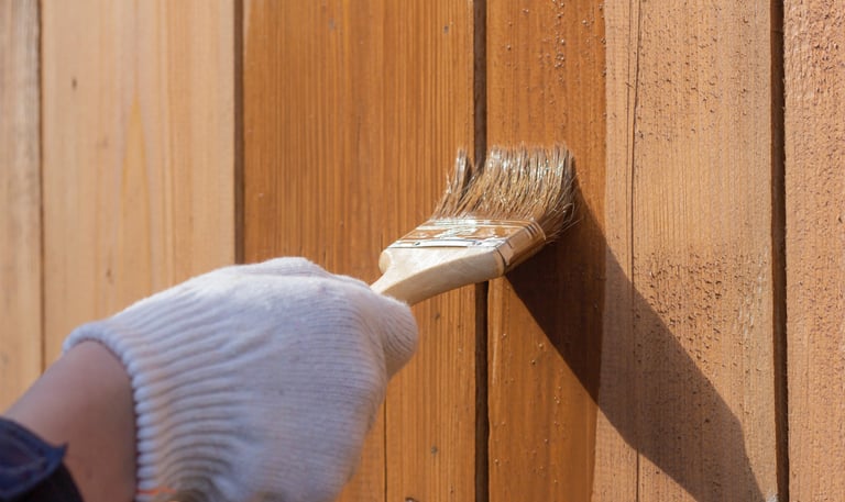 Application d'une protection pour bois sur une clôture verticale à l'aide d'un pinceau