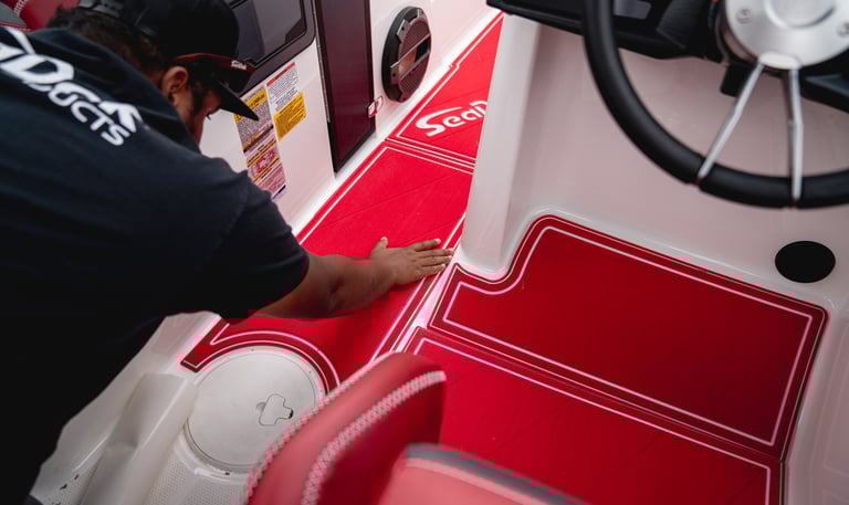 Vital Marine installer fitting custom red SeaDek flooring during professional boat deck installation