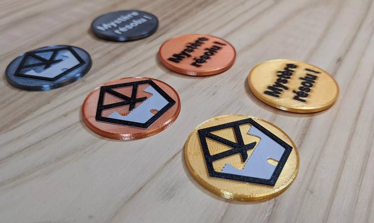 jetons imprimés en 3D avec le logo du musée et l'inscription Mystère résolu !