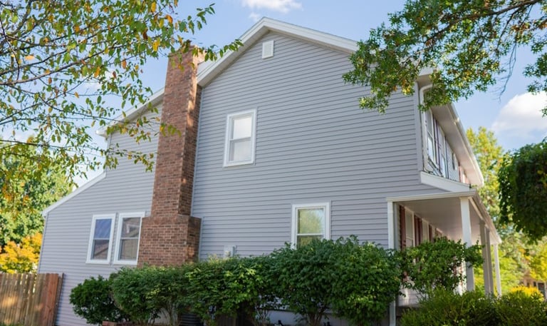 house with gray horizontal siding and white windows