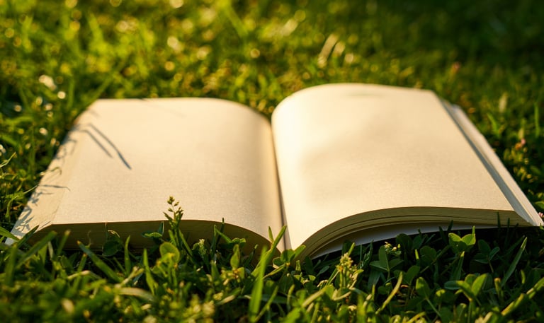Aufgeschlagenes Buch auf einer gruenen Wiese mit Trauerrede