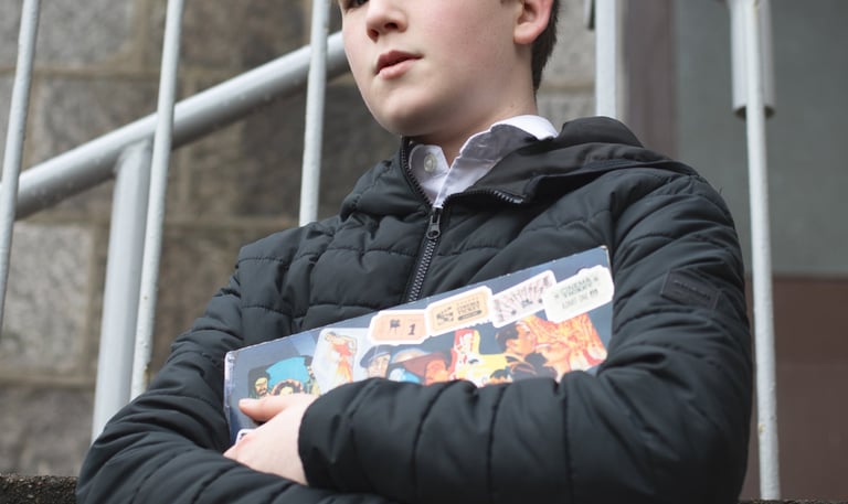 Film production: a boy in a black jacket holding a book