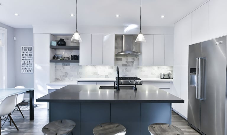 a kitchen with a stainless steel refrigerator and a large island