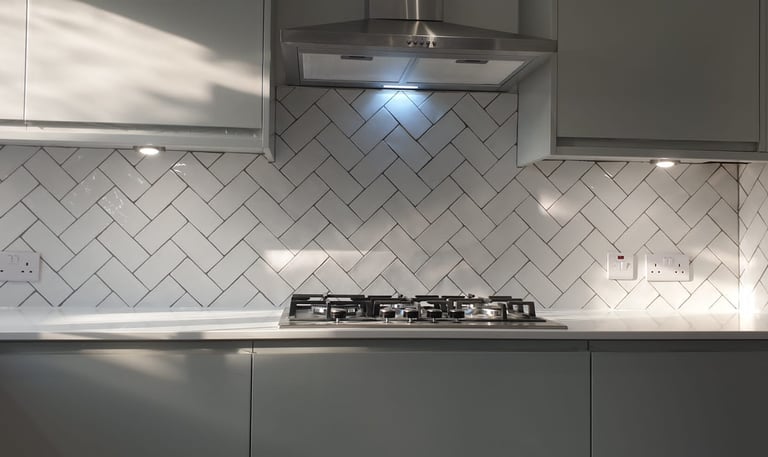 Modern white kitchen featuring a herringbone tile backsplash and stainless steel gas stovetop.