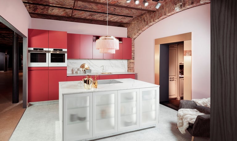 Una cocina con una isla roja y una encimera blanca.