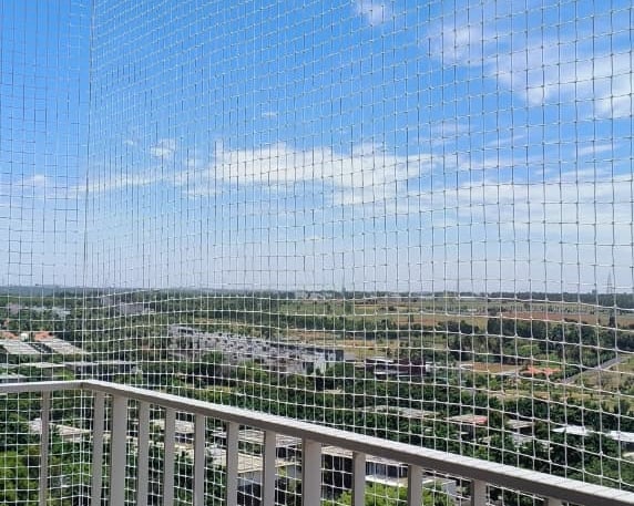 Technicians from Arjilli Safety Nets fitting a custom balcony net with precision tools.