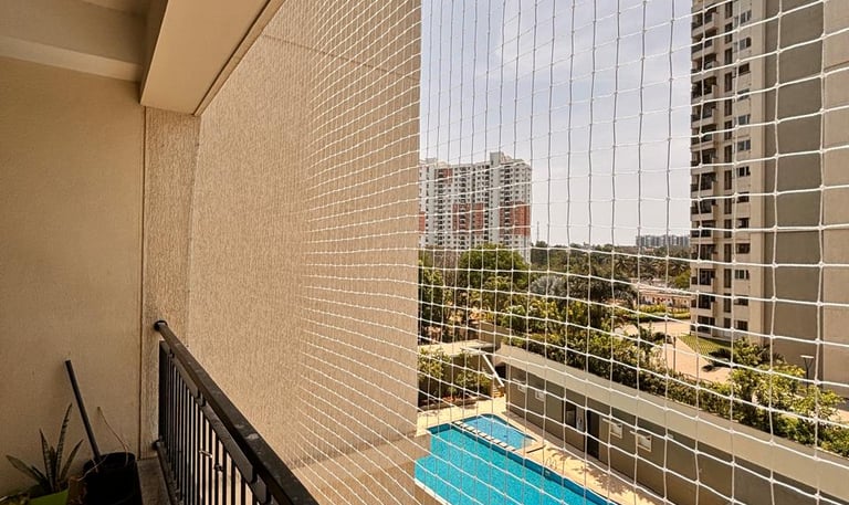 Wide shot of a high-rise balcony in Vasai with a neatly installed pigeon net.