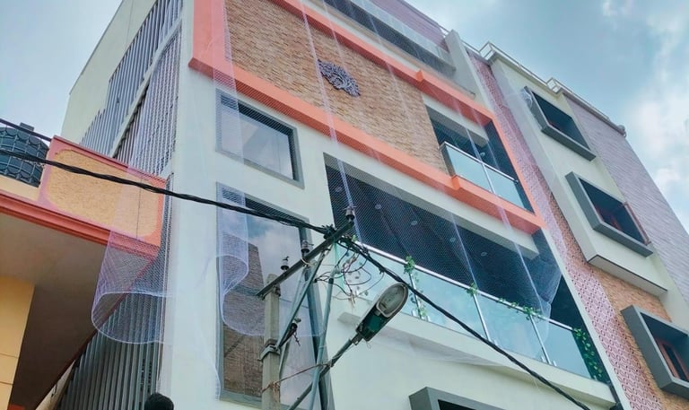 Wide shot of a modern balcony fitted with pigeon nets, showing neat installation and surrounding gre