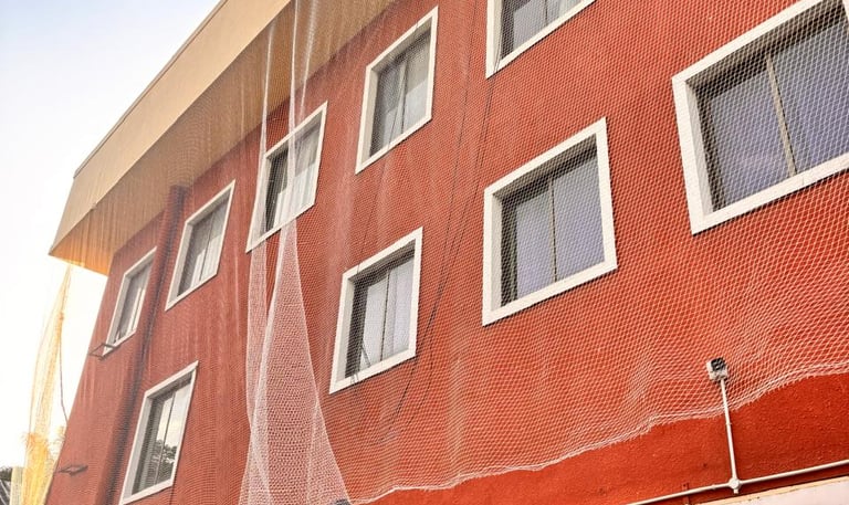 Wide shot of a high-rise Powai apartment complex fitted with seamless pigeon nets on all balconies.