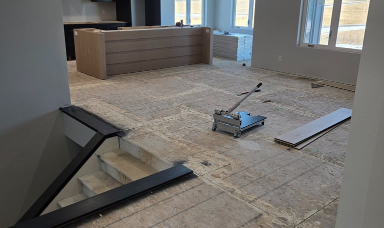 Modern home kitchen under construction with plywood subflooring and a laminate floor cutter tool.