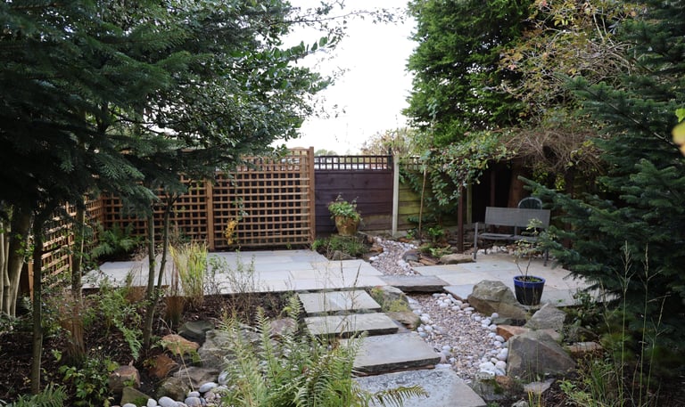 A garden design in Bury, Manchester showing stepping stones leading to a raised patio