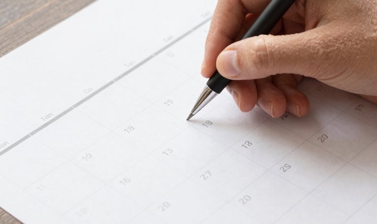A focused individual working intently on a laptop surrounded by notes and sketches.