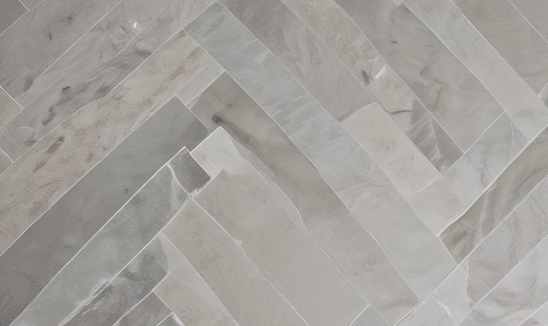 A tiled surface composed of small, square tiles in a grid pattern. There is a slight color variation indicating dampness on part of the surface. The corner of a shoe is visible at the bottom right corner.