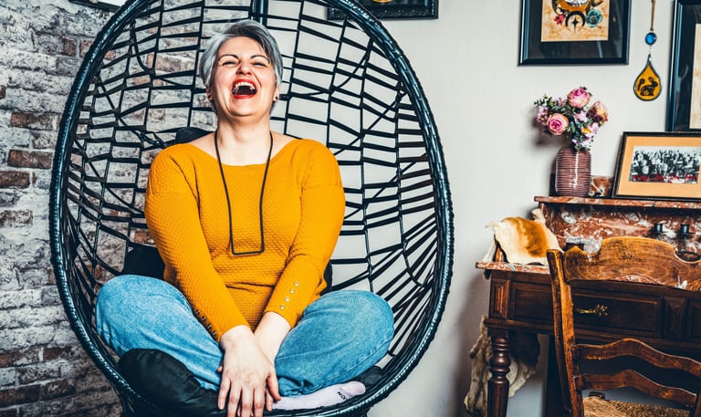 a woman sitting in a chair with a smile on her face
