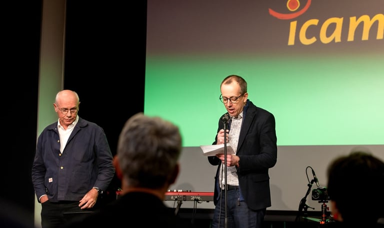 Un homme en veste noire un micro à la main