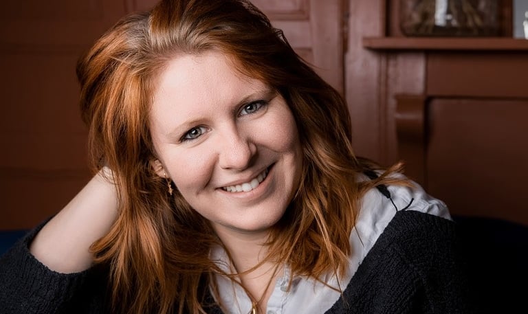 a woman with red hair and a black sweater