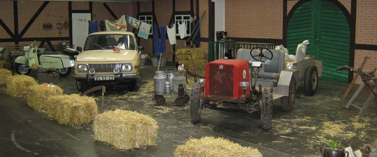 Messestand Techno Classica Essen mit Wartburg 353 und Eigenbau-Traktor in einer Bauernhof-Szenerie