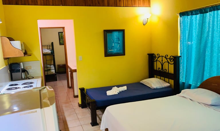 a bedroom with a bed and a kitchen