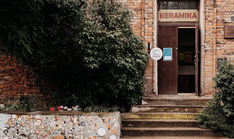 Old red brick house with open doors. On top of it is written: ceramics. 