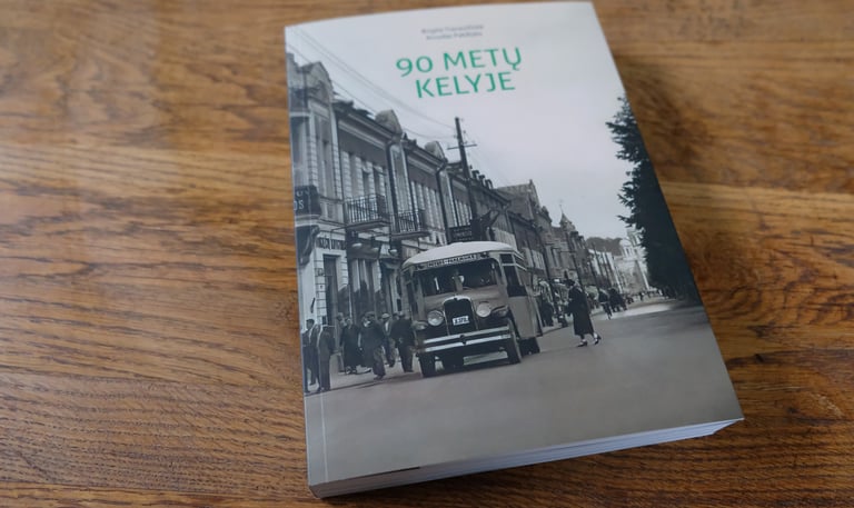 Cover of the book "90 Years on the Road". The photo on the cover shows a vintage bus driving along Laisvės Alėja. 