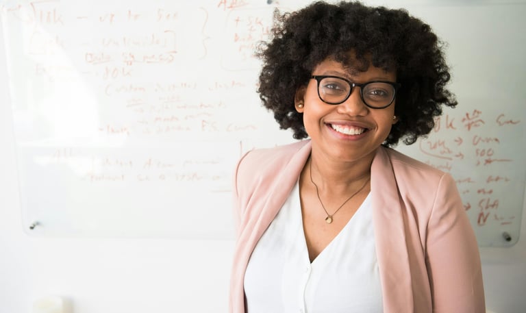 a woman in glasses and a pink jacket