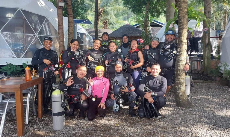 group of scuba divers, happily posing going into the dive in Dauin, Negros, the muck diving capital 