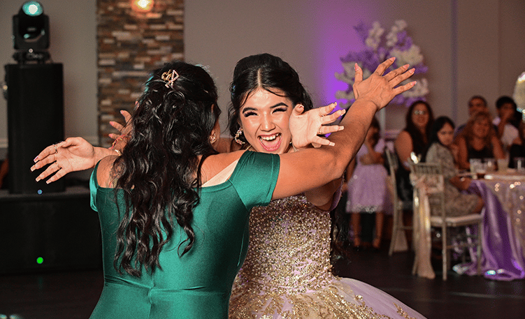 two women in green dresses dancing at a wedding