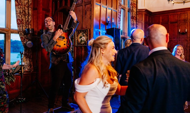 a man and woman playing guitar together in front of bride at wedding