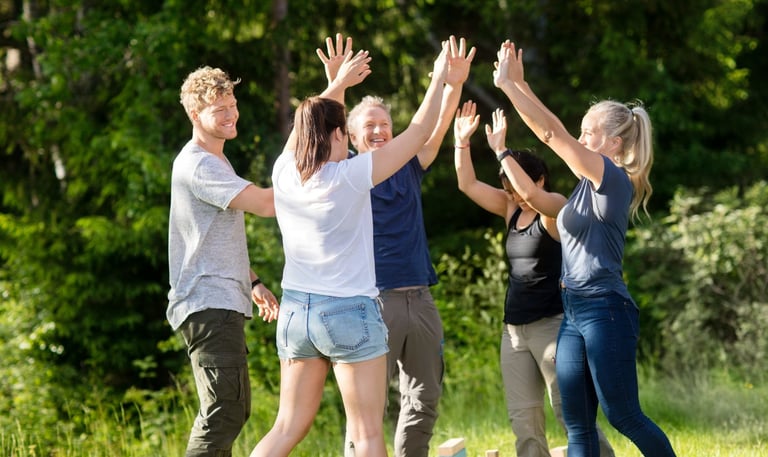 Team high-fiving and celebrating after winning a challenge during a team-building retreat