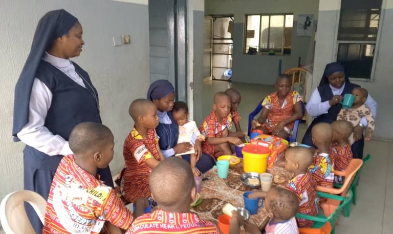 Catholic nuns caring for children during mealtime at an orphanage or school nursery.
