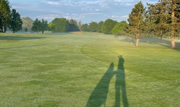 a person standing in a field with a golfbag