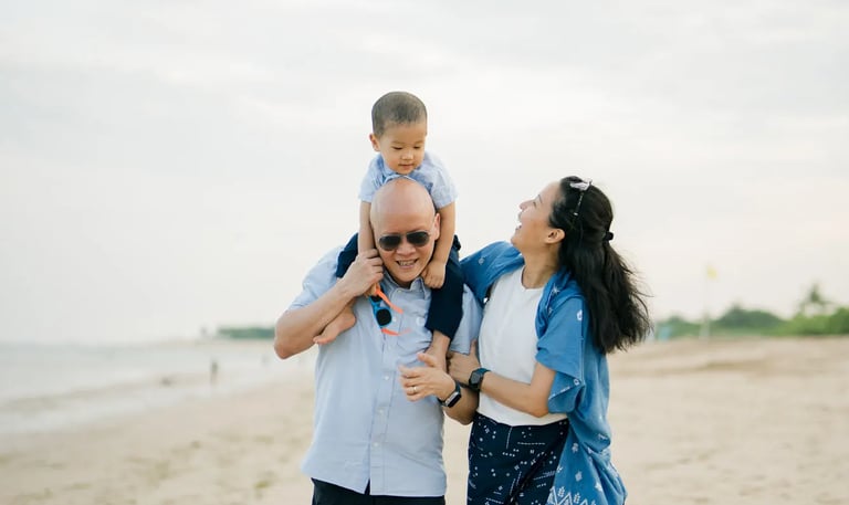 Parents embracing their son during a relaxed family photography session at Nusa Dua Beach Bali