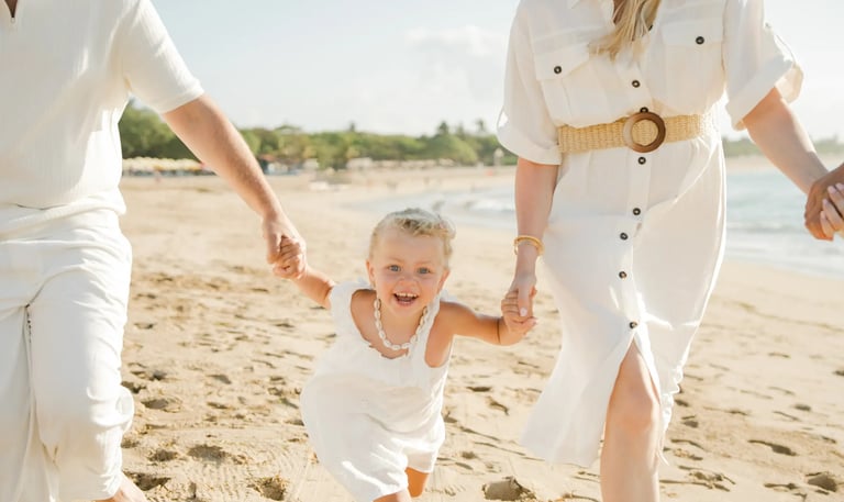 Young child running happily along the beach during a family photography session at Ayodya Resort Bali