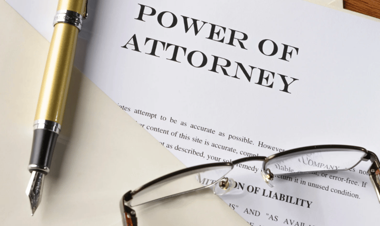 Power of attorney document with pen and glasses, symbolizing legal financial authority.