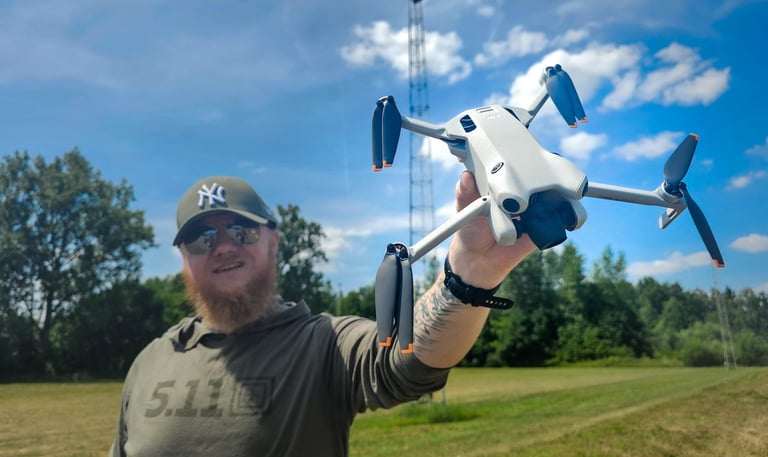 Dronepiloot toont DJI Mini 4 Pro drone in open veld tijdens voorbereidingen voor luchtinspectie op locatie