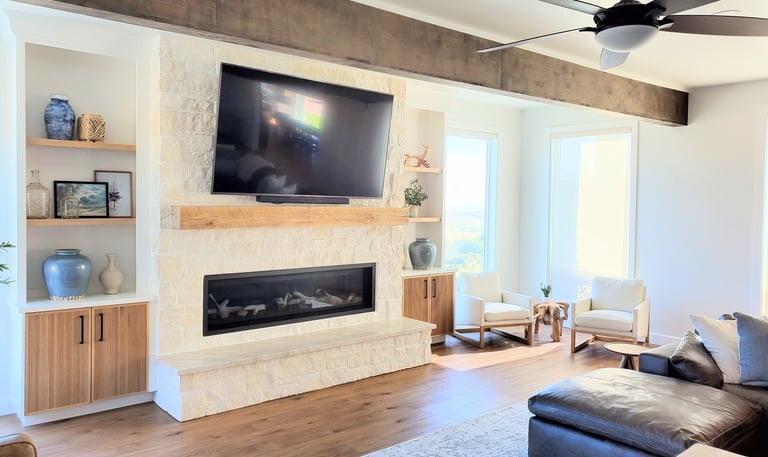 Living room remodel with exposed beams, white stone work fireplace with natural wood mantle. Colorado Springs construction.