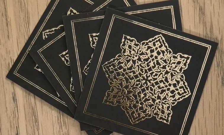 a set of four black and gold cards with a gold foiled design