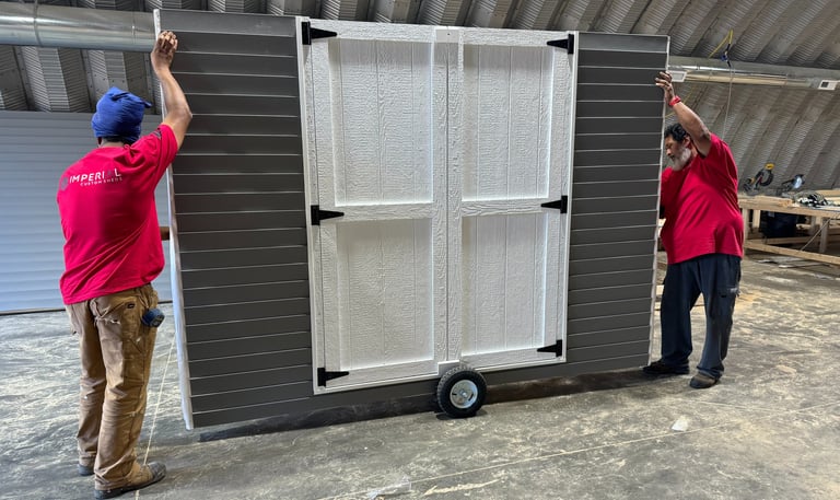 Imperial Custom Sheds crew moving a shed wall to load onto delivery truck for on-site installation