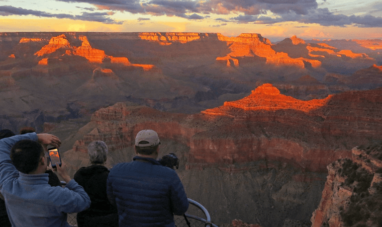 a group of people standing on a cliff overlooking a canyon