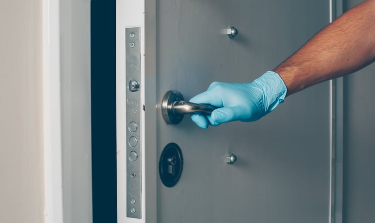 a person in gloves and gloves is holding a door handle