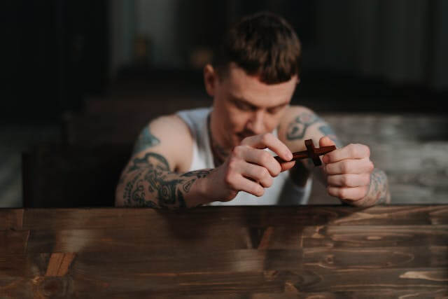a man with tattoos on his arm and a cigar