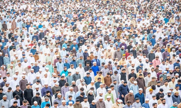 Large group of people gathered in prayer, standing closely together