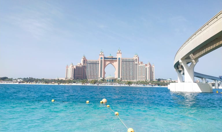 a bridge spanning the water with a bridge in the background in Palm Jumeirah dubai