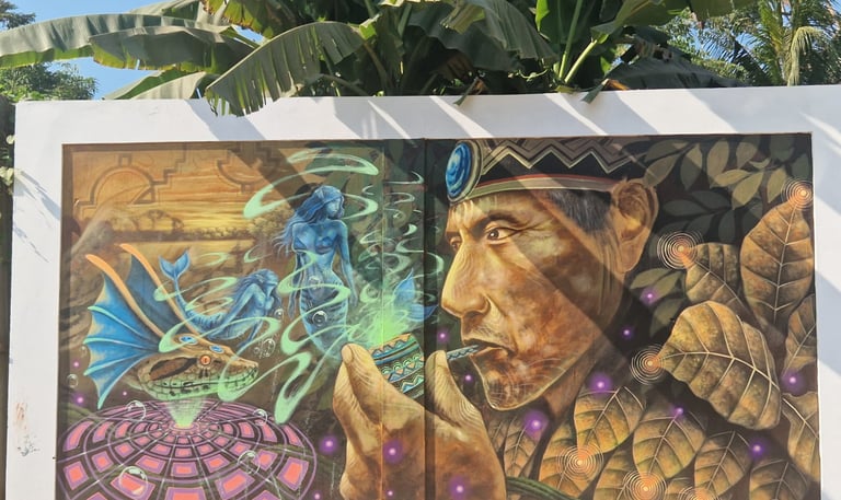 Mural painting of an indigenous shaman with a tobacco pipe and mystical spirit figures under banana leaves.