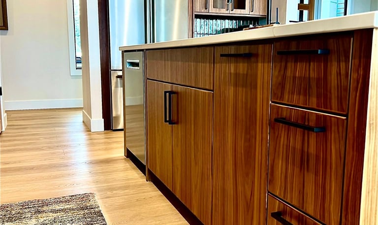 Modern kitchen with walnut wood cabinets, stainless steel appliances, and a black faucet.
