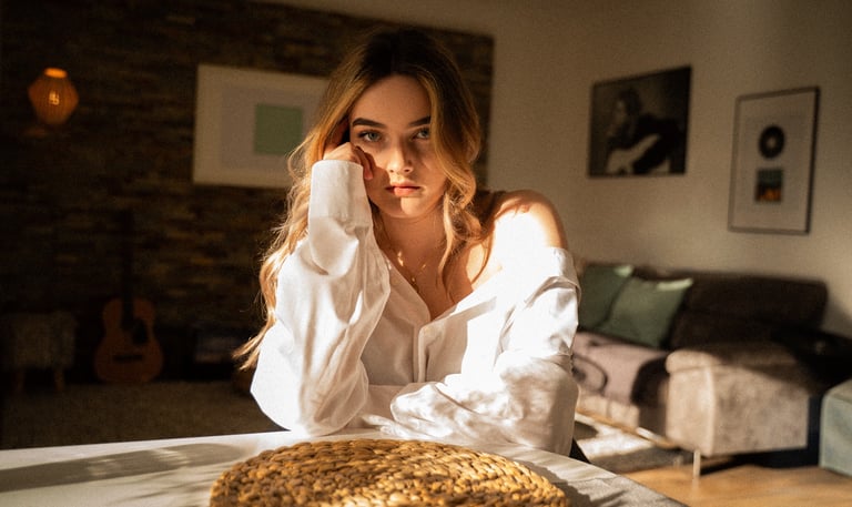 Natürliches Portrait im weichen Fensterlicht – stille, filmische Stimmung im Innenraum.