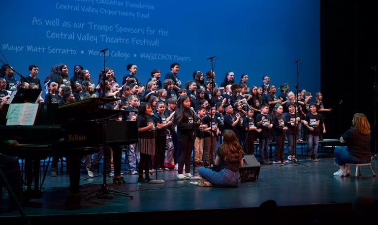 A diverse youth choir performing on a stage during the Central Valley Theatre Festival.
