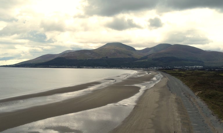 A picture of Royal county down golf club with the mourne mountains behind